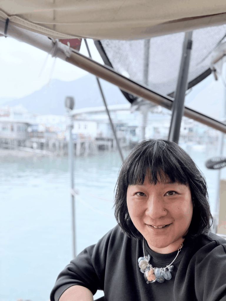 Tania Chau smiles at the camera with water in the background